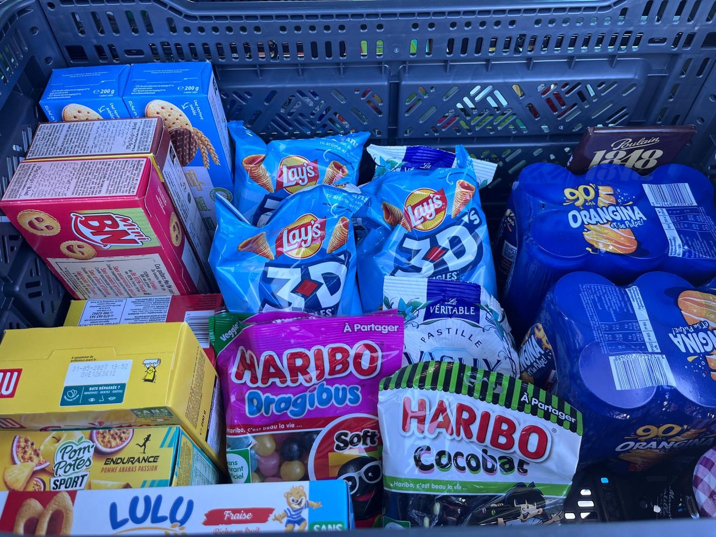 Haribo, Orangina, Lay’s, Mini BN and Lulu in a crate